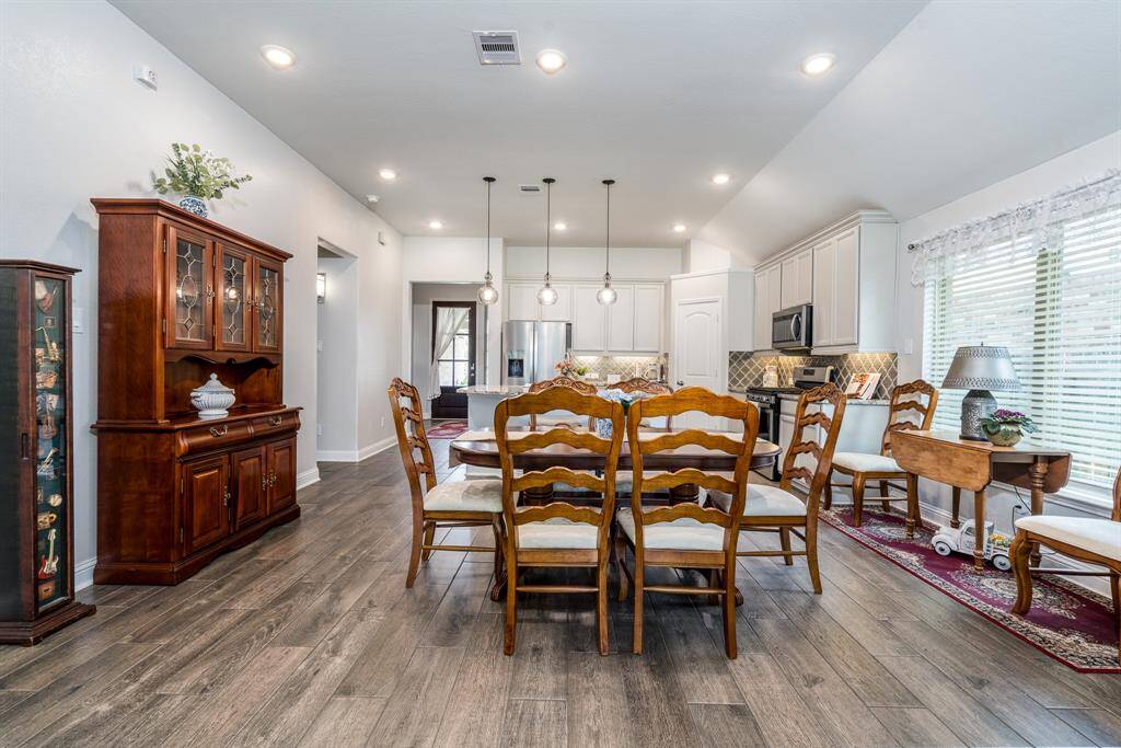 Above the island, pendant lighting adds a touch of elegance and warmth, perfectly complementing the kitchen's stylish design. The beautiful tile flooring enhances the space, offering both durability and aesthetic appeal.