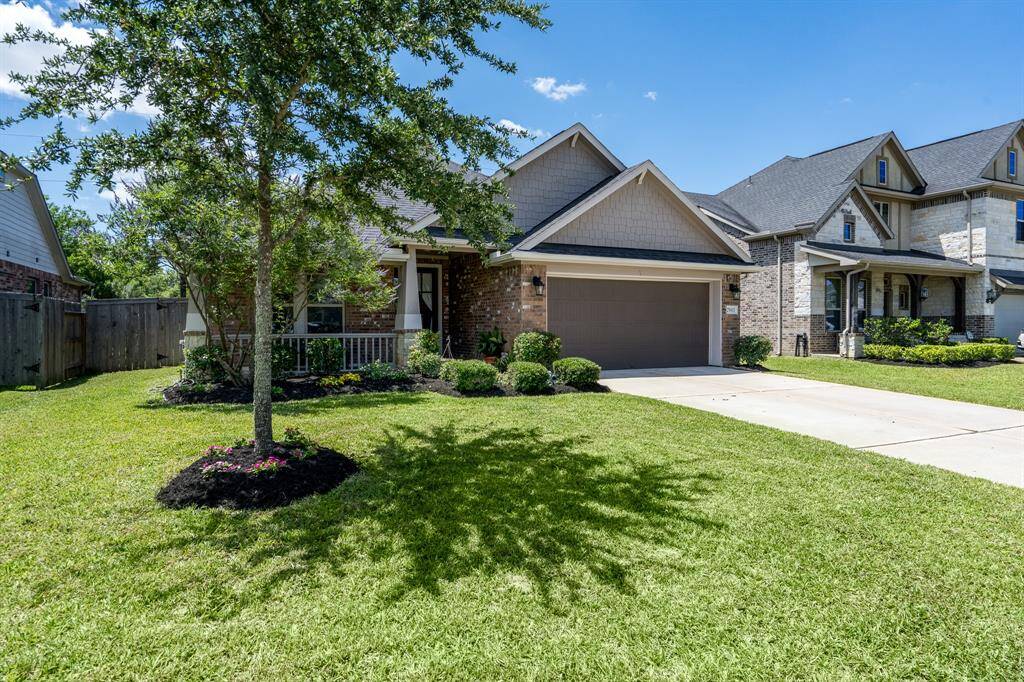 The front yard features mature landscaping that adds natural beauty and a welcoming touch to the home's exterior.