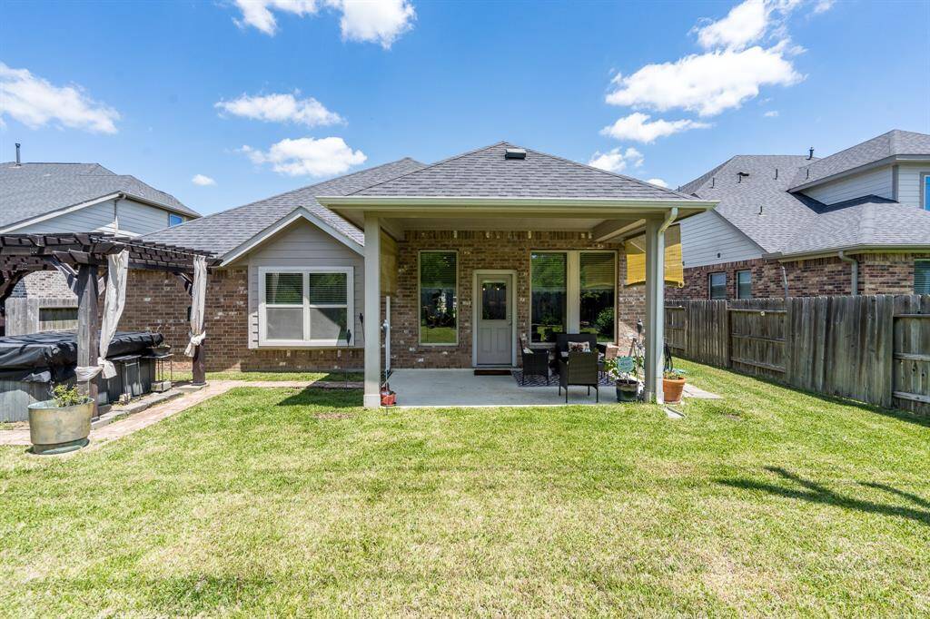 The backyard features a hot tub and a covered patio, creating an ideal space for outdoor relaxation and entertainment, offering a perfect escape from everyday life.