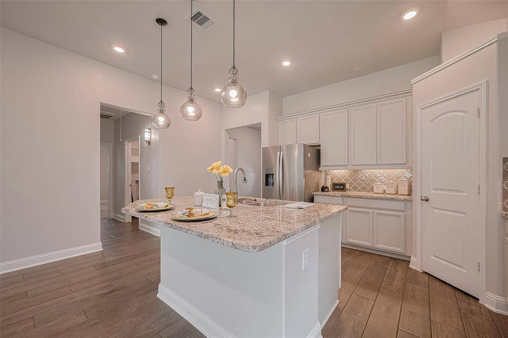 The primary bath features double sinks and bright lighting, offering plenty of space and style for your daily routine.