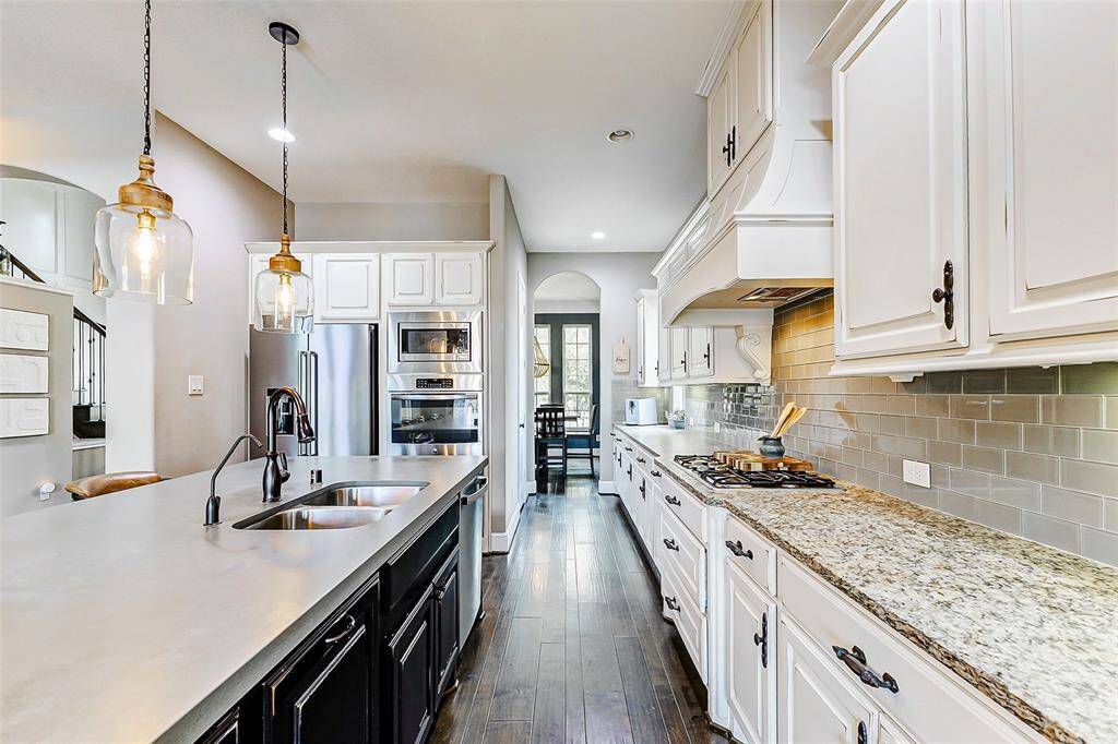 The kitchen also features electric double ovens with a built-in microwave above, offering convenience and efficiency. Additionally, the home is equipped with a reverse osmosis filtration system and a whole-house water softener, ensuring both quality and comfort.