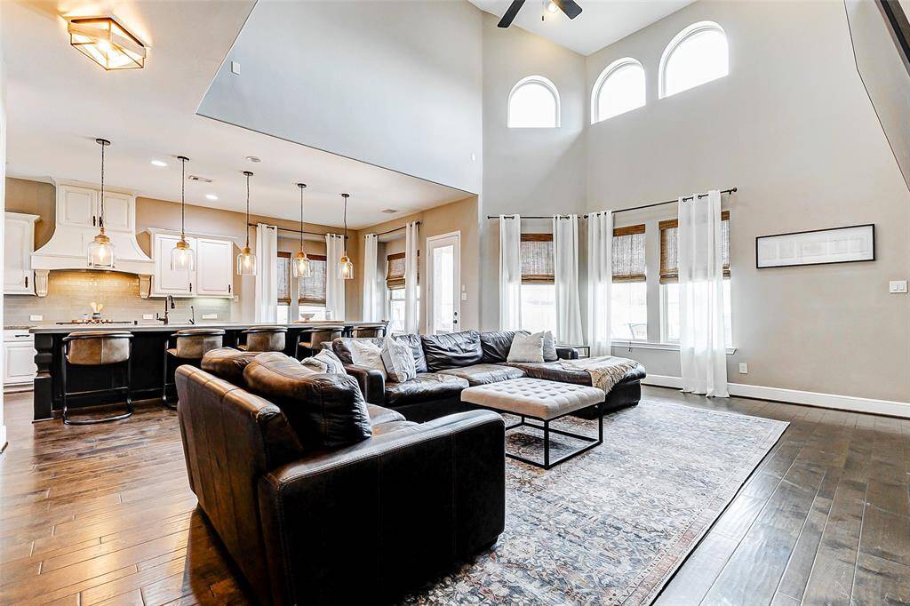 Allow your gaze to be drawn to the expansive picture windows that line one wall, along with three gracefully arched windows that flood the living room with natural light. These windows offer a seamless connection to the stunning backyard oasis, inviting the outdoors in.