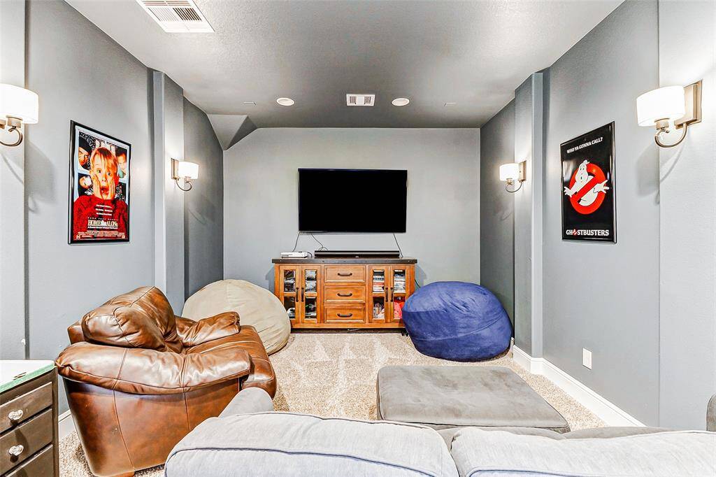 Welcome to your private media room, thoughtfully designed with dark walls and ambient wall sconces to set the perfect cinematic mood for movie nights, gaming, and immersive entertainment.