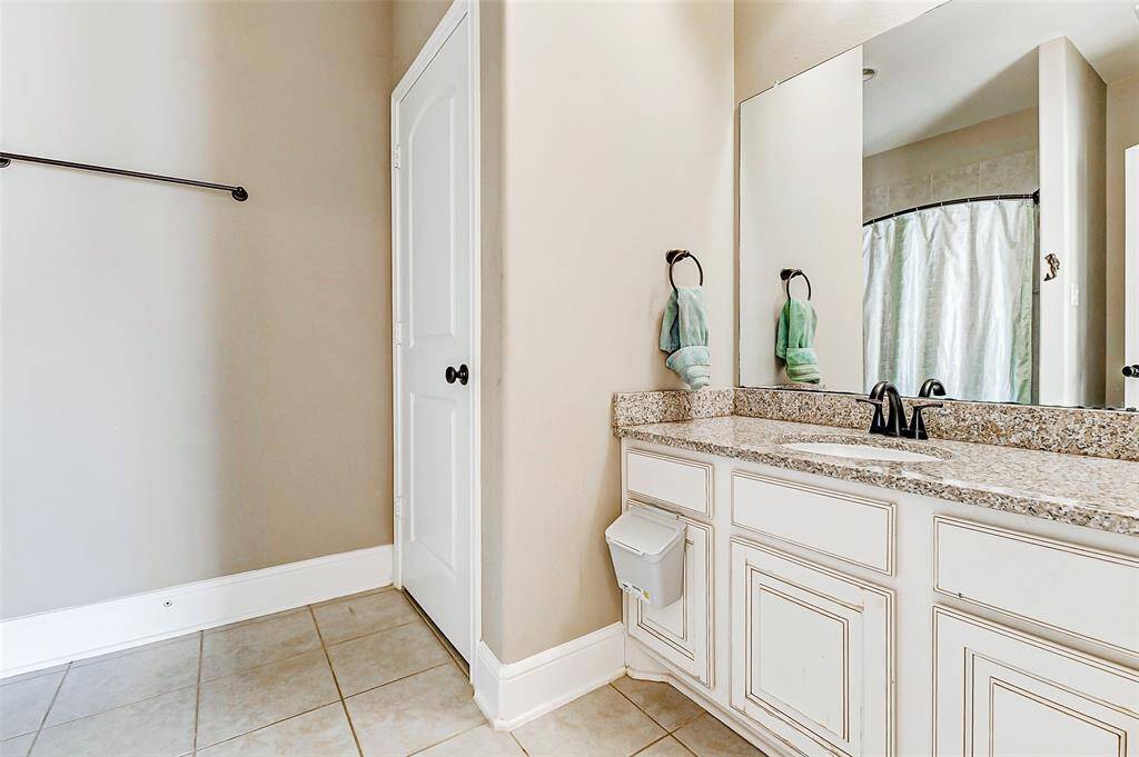 This guest bathroom also includes an extended vanity with elegant bronze finishes, adding a touch of sophistication and functionality to the space.