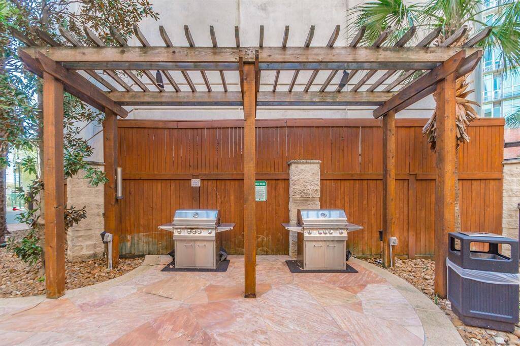 Community summer kitchen w custom arbor, flagstone decking & 2 stainless steel gas grills