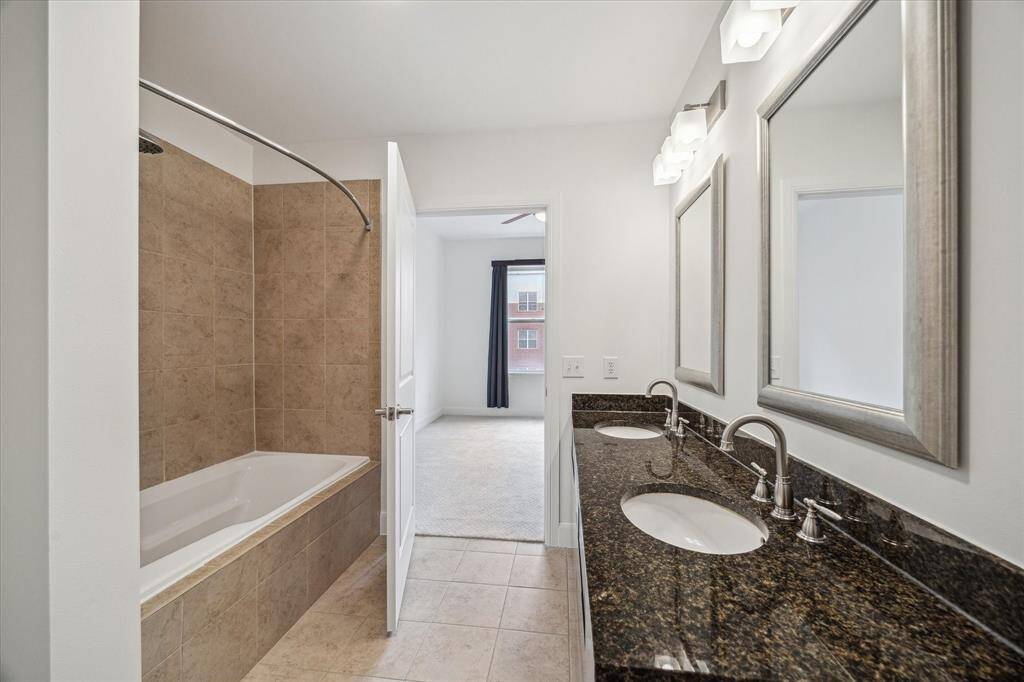 Immaculate granite primary bedroom w double sinks, tile tub/shower & chrome fixtures