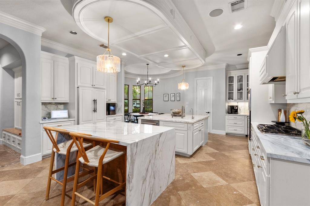 Spacious island kitchen with seating with pendant lighting, a blend of classic and contemporary design elements.  A bright and inviting space perfect for cooking and entertaining.