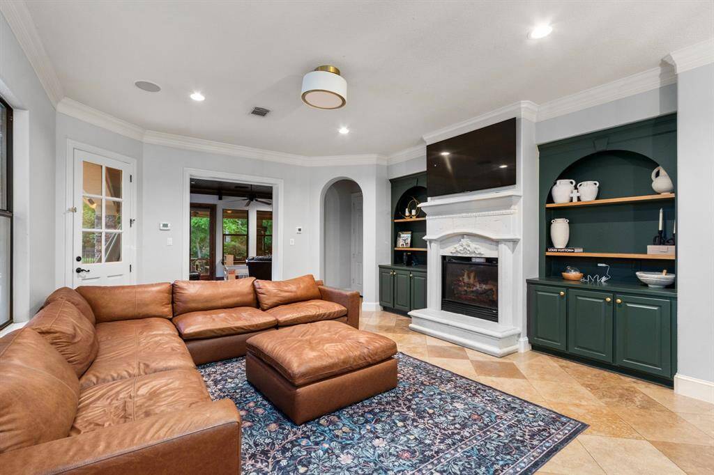 Cozy living room with elegant stone fireplace, and built-in cabinetry.