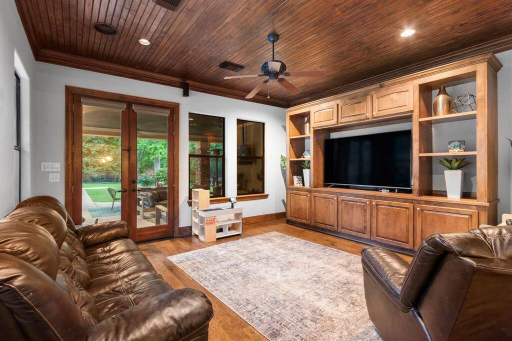 This cozy additional living space features warm wood accents with a paneled ceiling and built-in entertainment center. It could be additional den space or a "Man Cave" or game room.  It is off the patio and kitchen.