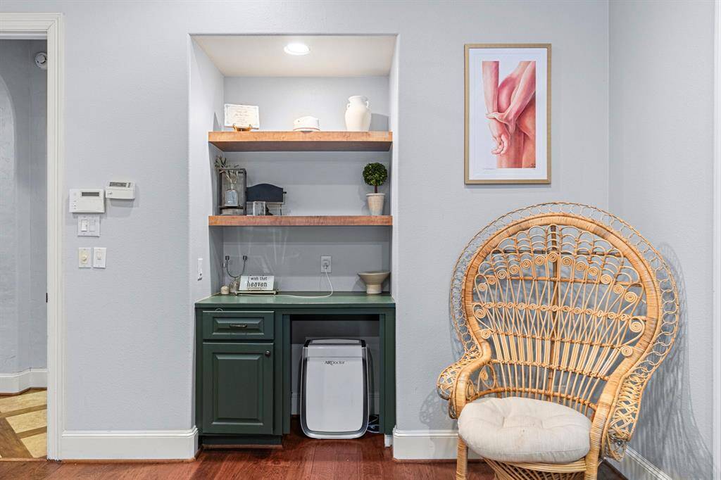 Cozy nook in the primary featuring built-in shelves, cabinet, and a mini-fridge.
