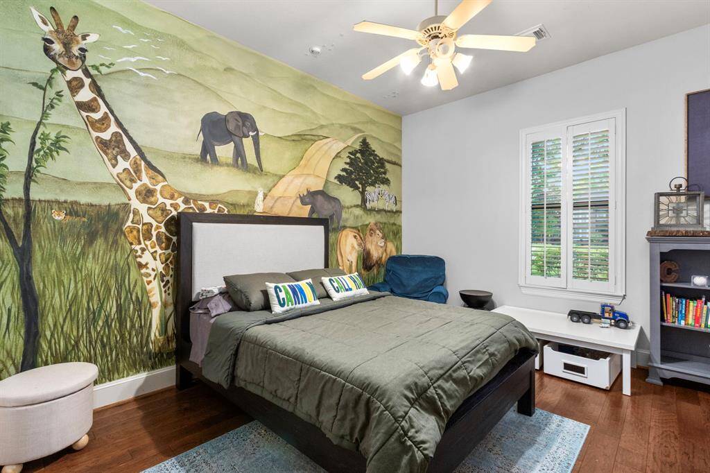 This bedroom features a playful safari-themed mural  creating a vibrant and imaginative space. It is ideal for a child's room.