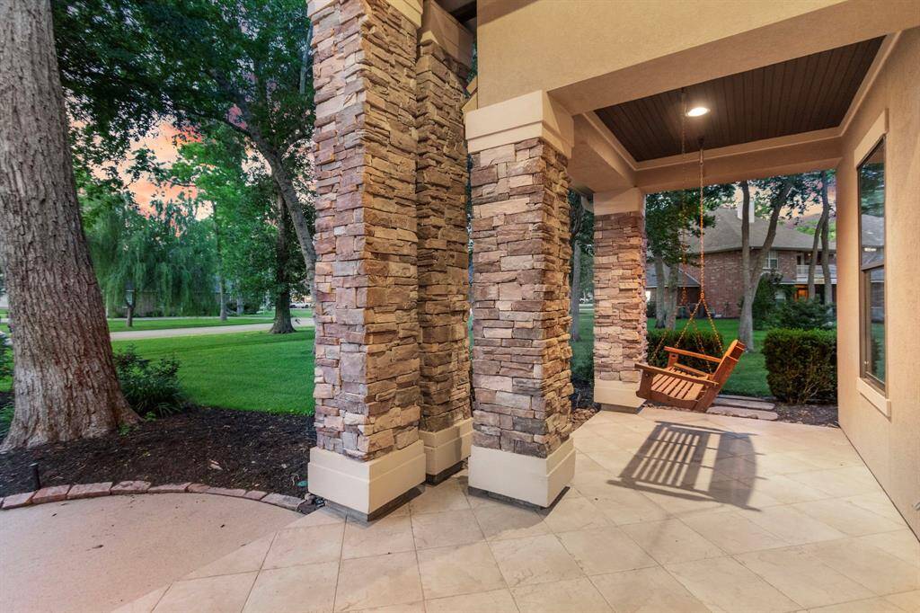 Charming porch with a stone pillar design, featuring a cozy wooden swing to view the Eastern bluebirds, cardinals and whistling ducks who visit often.