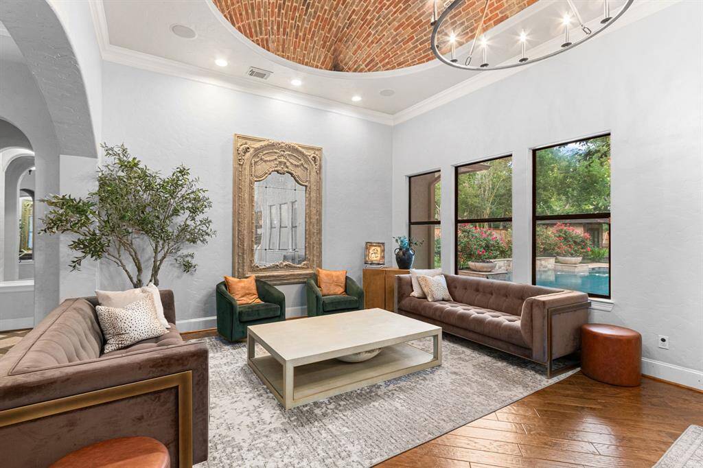 Spacious living room  featuring a stunning brick dome ceiling and large windows offering a view of the pool area.