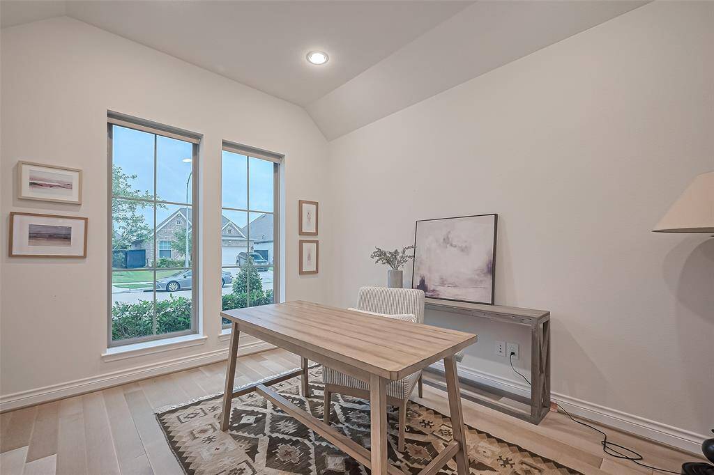 Just off the foyer, a versatile home office or flex space awaits, complete with double glass doors and a lovely view of the manicured front yard—an ideal environment for remote work, study, or personal pursuits.