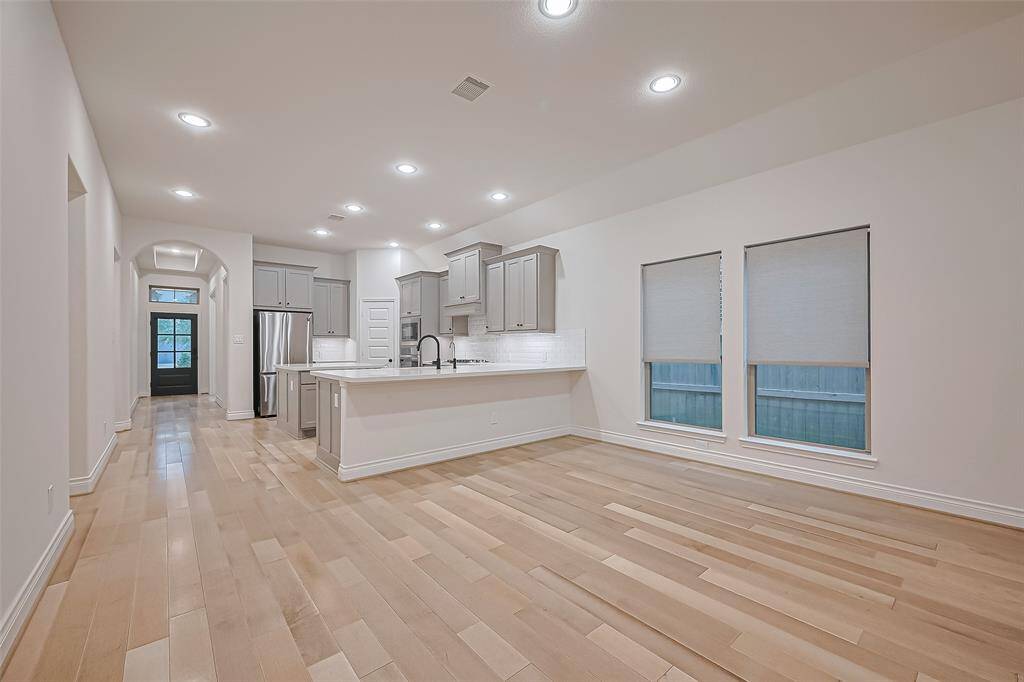 The heart of the home features an expansive open-concept layout, where recessed lights blend into the ceiling providing an abundant of light and upgraded tile flooring flows seamlessly through the main living areas.