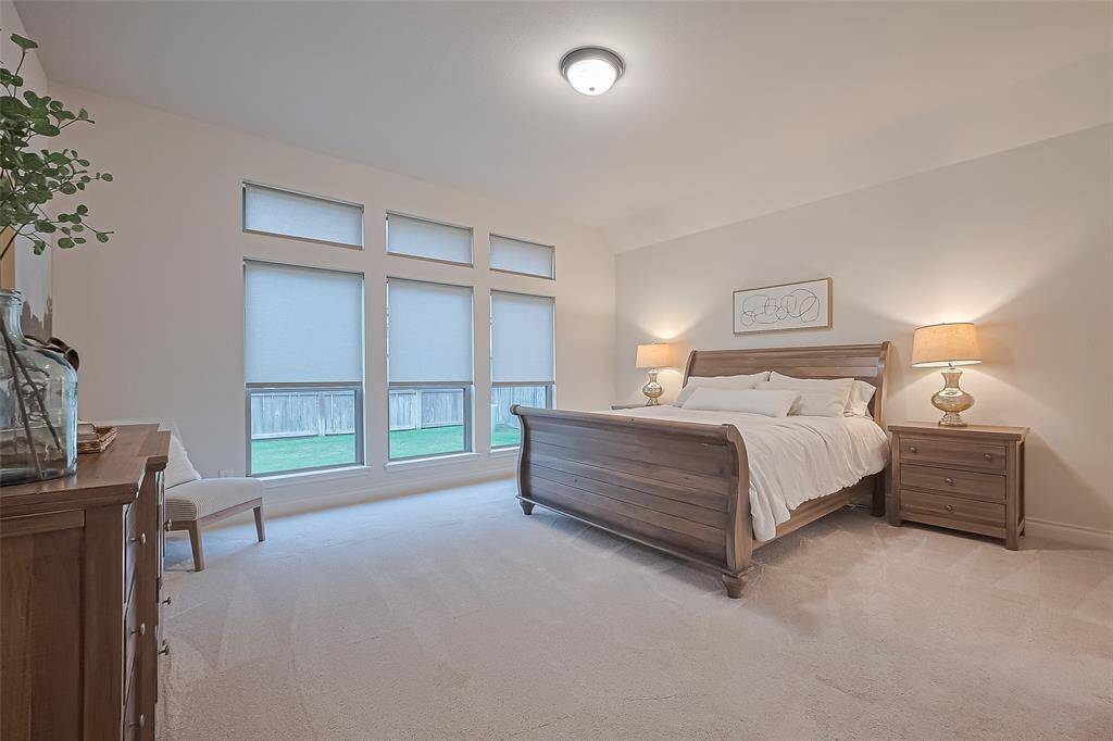 Tucked away at the rear of the home, the luxurious primary suite is a tranquil retreat, offering three large windows that overlook the backyard and flood the room with natural light. Plush upgraded carpet adds warmth and comfort to all the bedrooms.