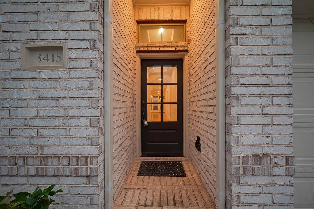 The charming front porch and impressive modern glass and wood front door set the tone for the sophisticated interiors that lie beyond.