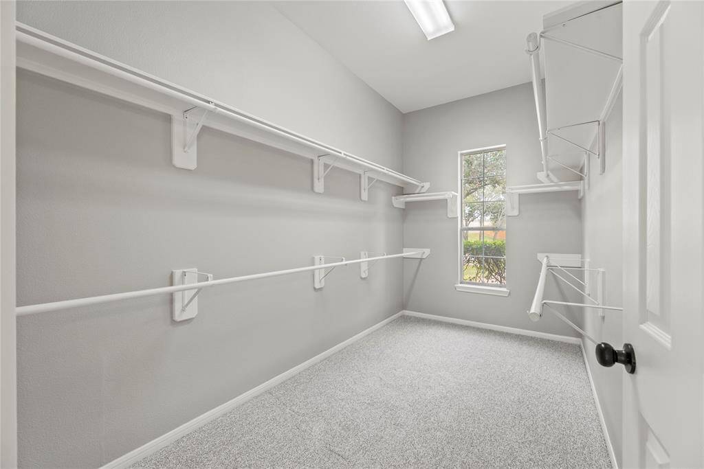 No matter how often you purchase new threads online or at the mall, this walk-in primary bedroom closet has space for all your new and favorite wares! High ceilings also afford the possibility of additional shelving or easy stacking.