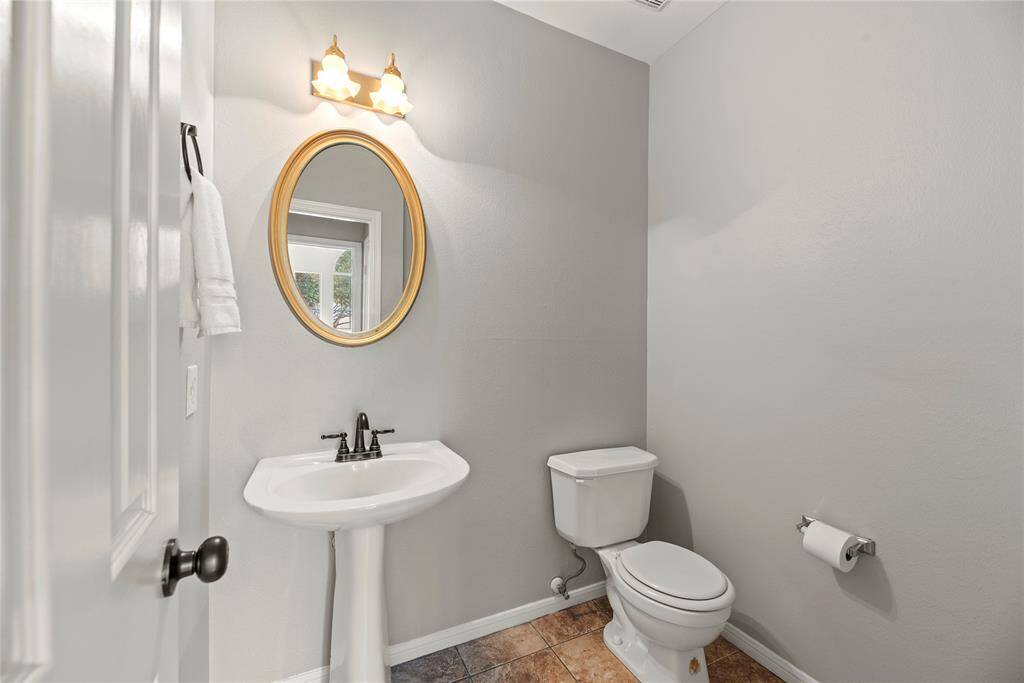 Hospitality is felt throughout the home and the powder room is no exception. Antiqued in style, the lovely pedestal sink is just the right size for visitors and guests.