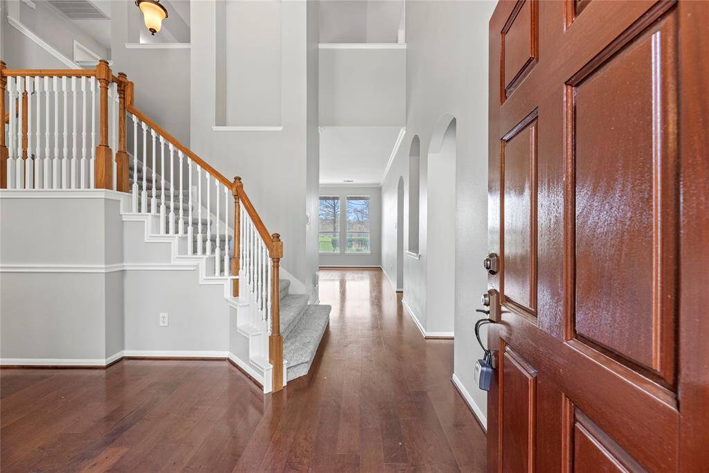 Grand and spectacular, the two-story foyer makes an impression on all your guests! Richly toned hardwood floors gleam in the presence of luminous natural light, while the above light fixture adds a touch of luxury.