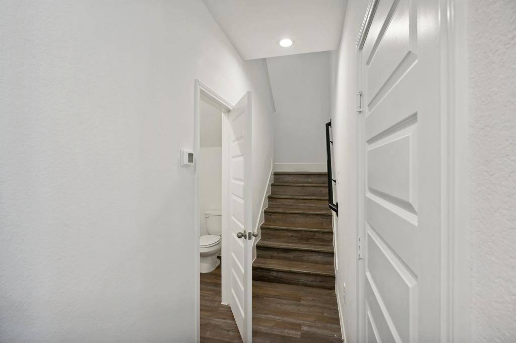 Hallway with half bath and stairs to second floor