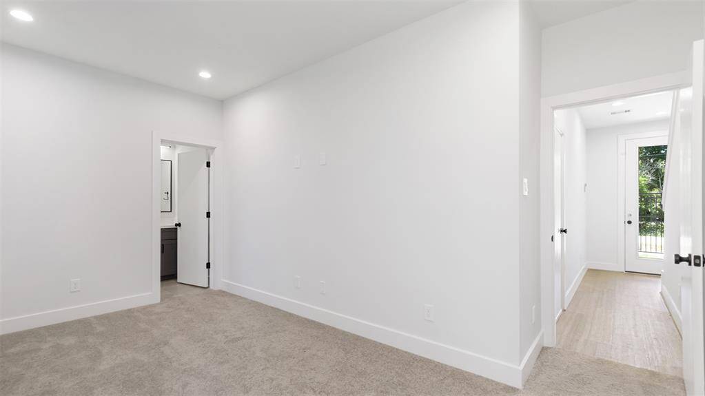 The first floor bedroom features plush carpet and recessed lighting.