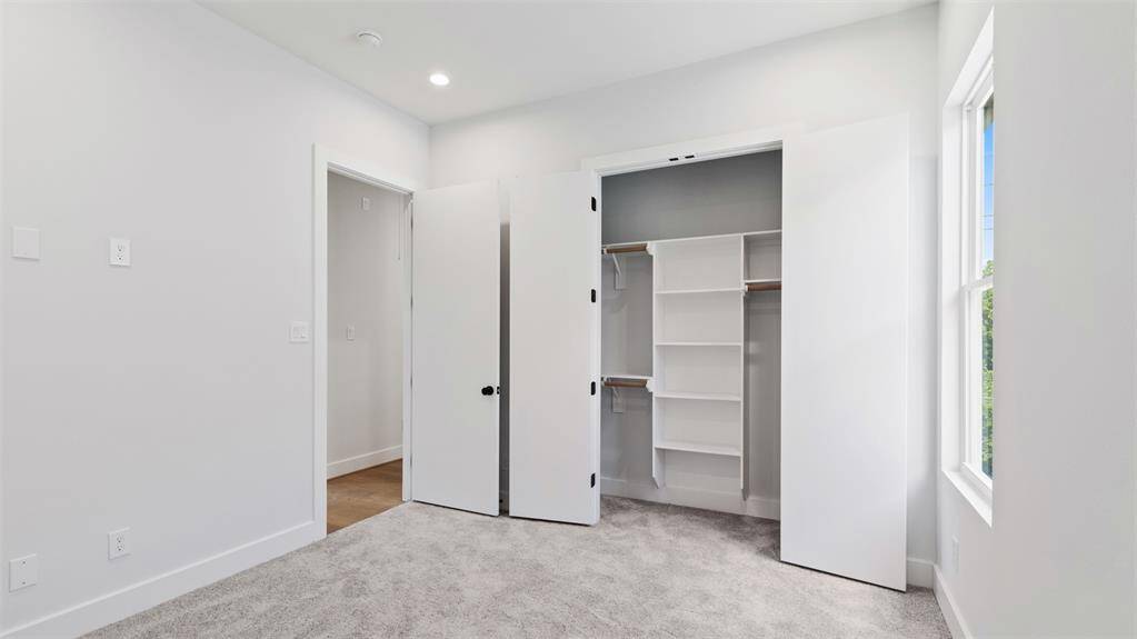 Secondary bedroom features awindow and plush carpet.