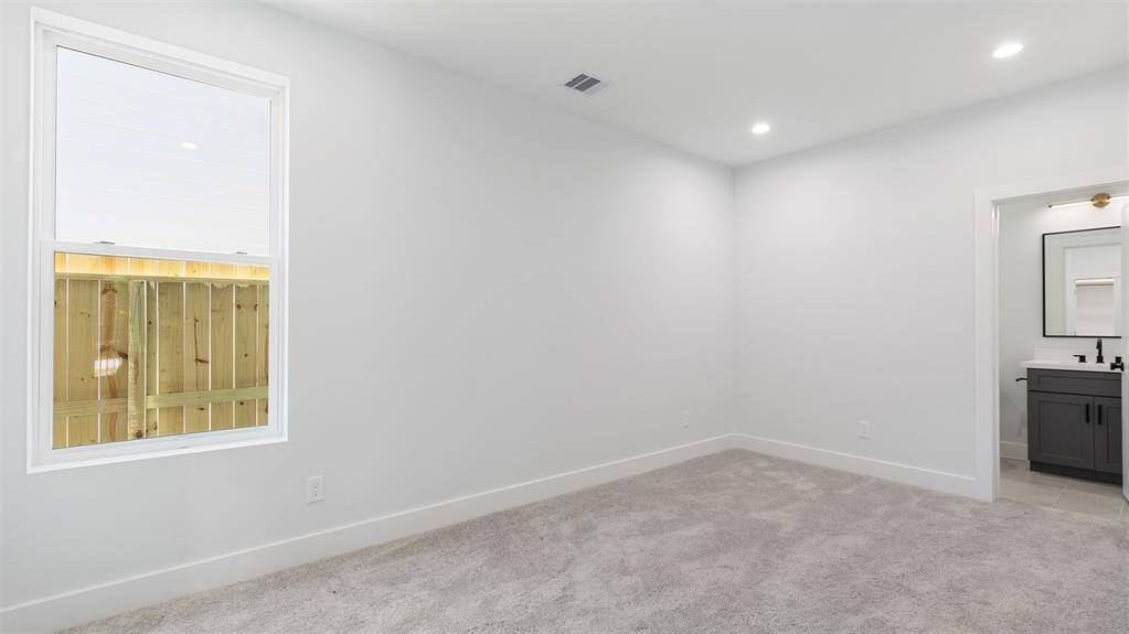 The first floor bedroom features plush carpet and recessed lighting.