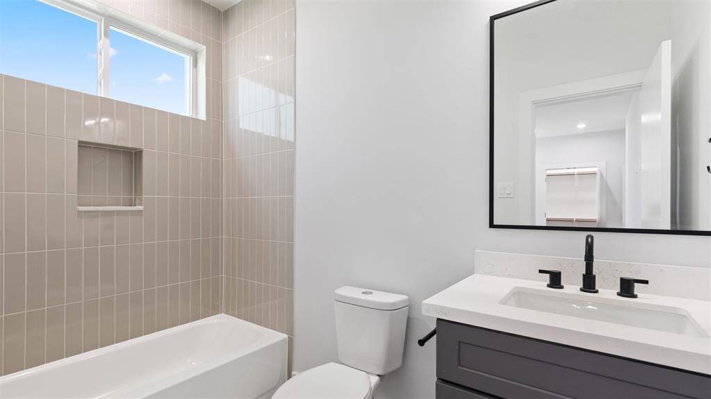The first floor bathroom features a tub and shower combo with tile surround.