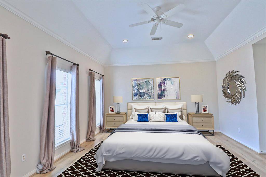This beautifully virtual staged primary bedroom boasts new laminate flooring and a stunning vaulted ceiling.