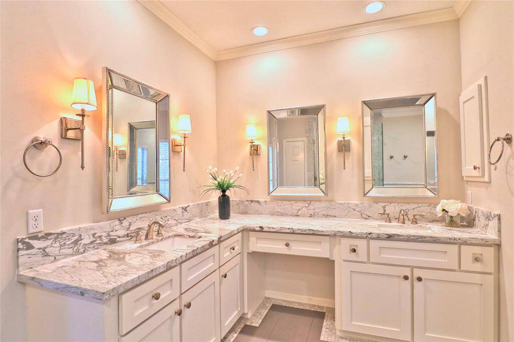 Luxurious primary bathroom featuring elegant marble countertops.
