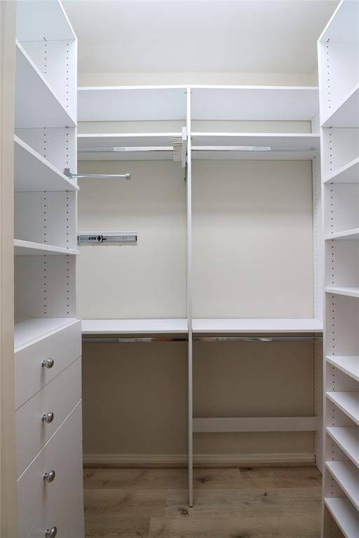 first Spacious and organized primary bedroom closet with ample shelving and storage solutions.