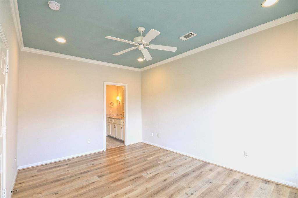 Secondary Bedroom 1 boasts new laminate flooring, a ceiling fan, and fresh paint.