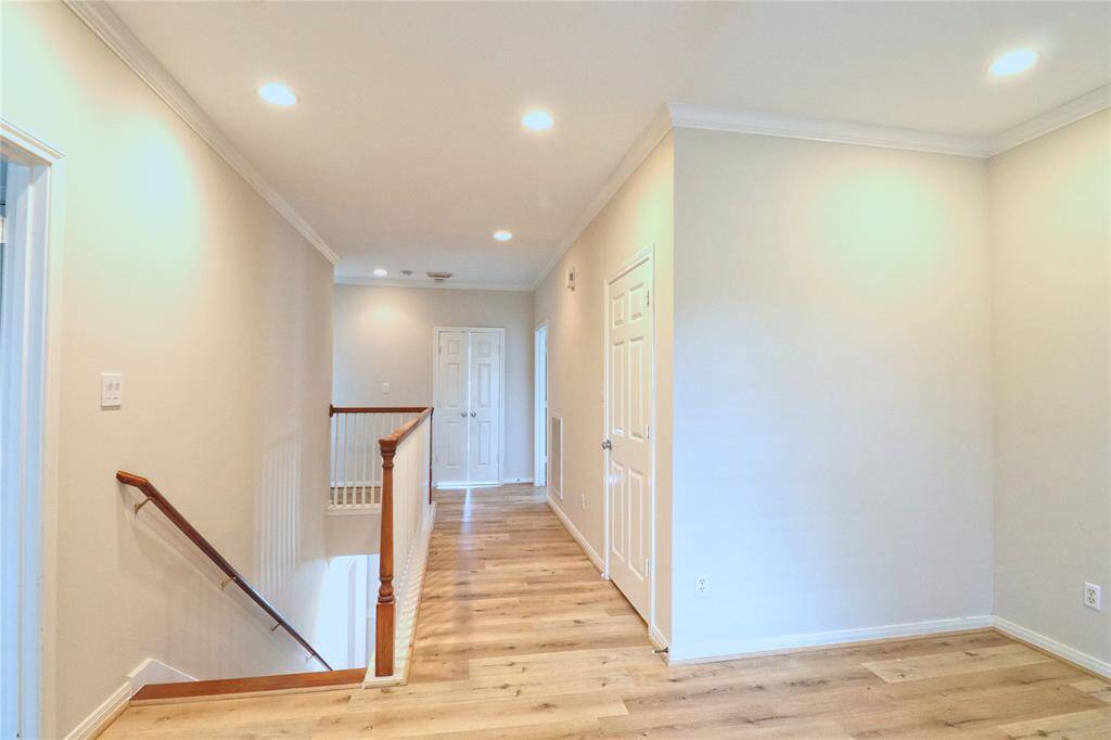 Elegant second-floor hallway featuring new laminate flooring.