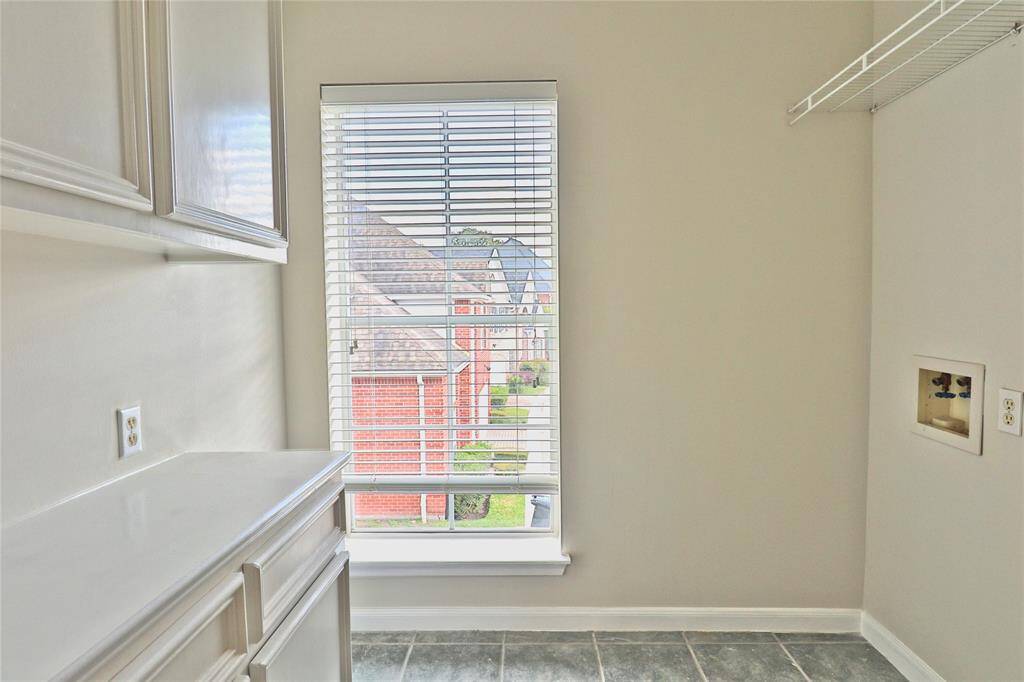 Spacious second-floor utility room with convenient built-in cabinets.