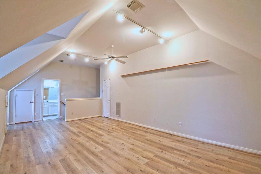 Expansive third-floor bedroom featuring new laminate flooring and an en-suite bathroom.