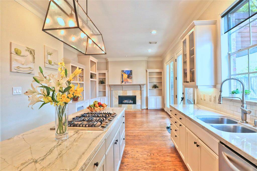Stunning kitchen with quartz countertops, adjacent to a cozy breakfast room featuring built-in bookcases and a gas log fireplace.