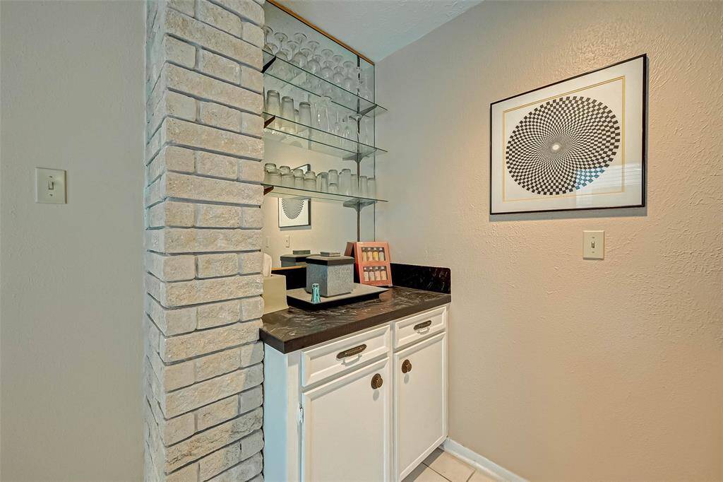 Glass shelving, counter space and storage for the wet bar area.