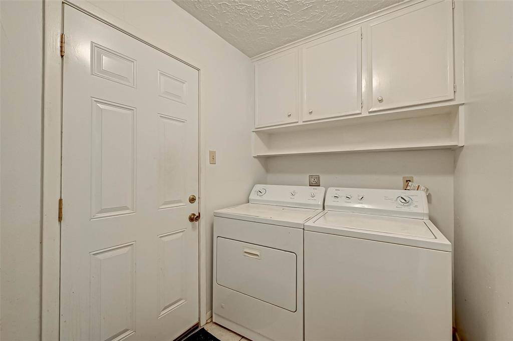 Large utility room with storage cabinets and shelving.  Electric and gas dryer connection.