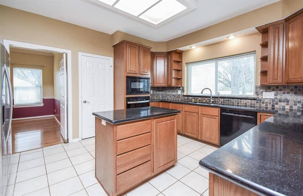 A stylish kitchen featuring warm wood tones, elegant tile flooring, and a well-planned layout for seamless cooking experiences