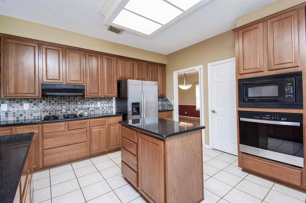A functional and beautifully designed kitchen space with granite countertops, ample cabinetry, and modern appliances
