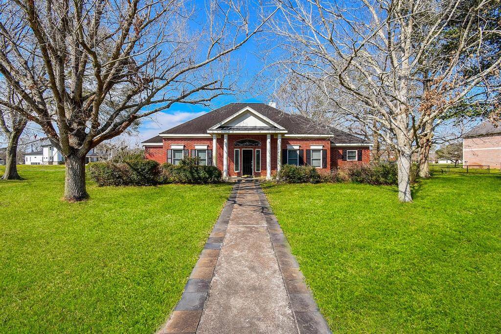 A charming brick home with a well-manicured front yard and a picturesque walkway leading to the entrance, exuding warmth and curb appeal.