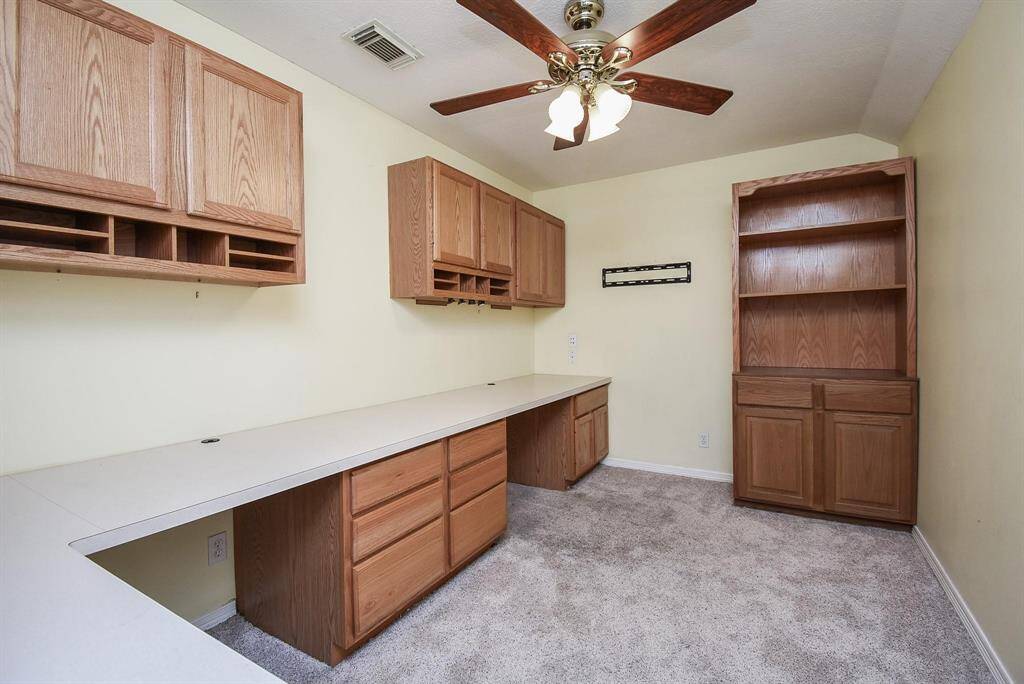 A built-in desk area with rich wood cabinetry, ideal for a home office or study space, blending functionality with style.