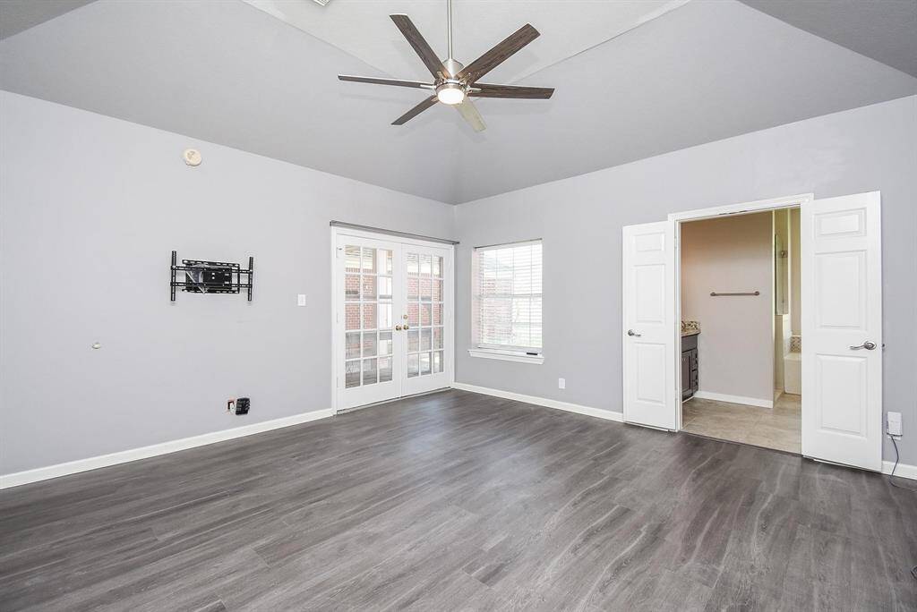 The high ceiling, stylish flooring, modern ceiling fan and patio access make this the ideal primary bedroom.