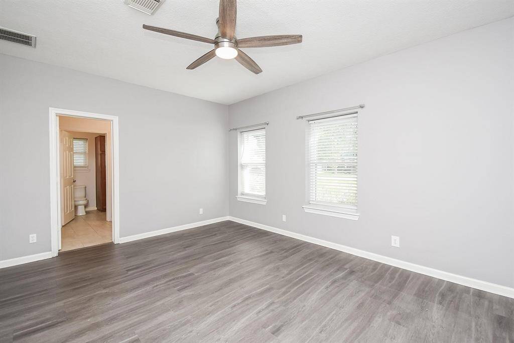 A bright and spacious bedroom with modern finishes, a ceiling fan for comfort, and a layout that maximizes space and light