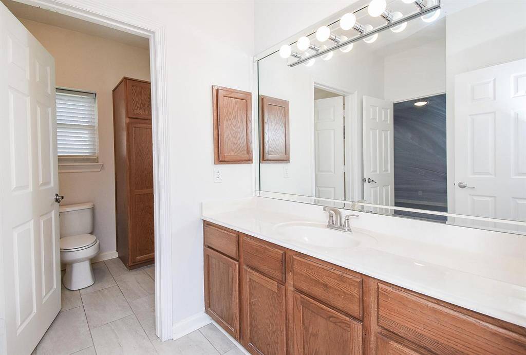 A beautifully designed bathroom with a double vanity, stylish lighting, and ample storage, offering both elegance and convenience.