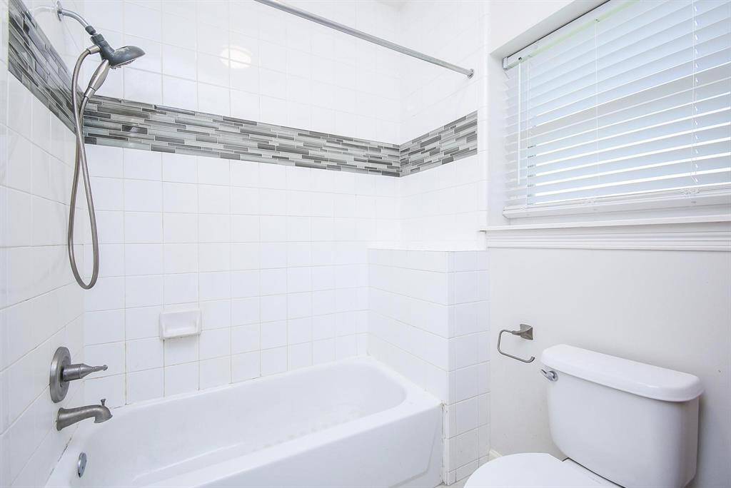 A bright and modern bathroom with a walk-in shower featuring sleek fixtures and accessibility-friendly design elements.