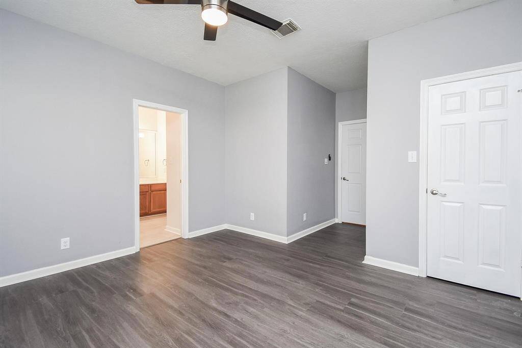 A contemporary bedroom with stylish flooring, neutral walls, and a spacious layout, perfect for relaxation and personalization.