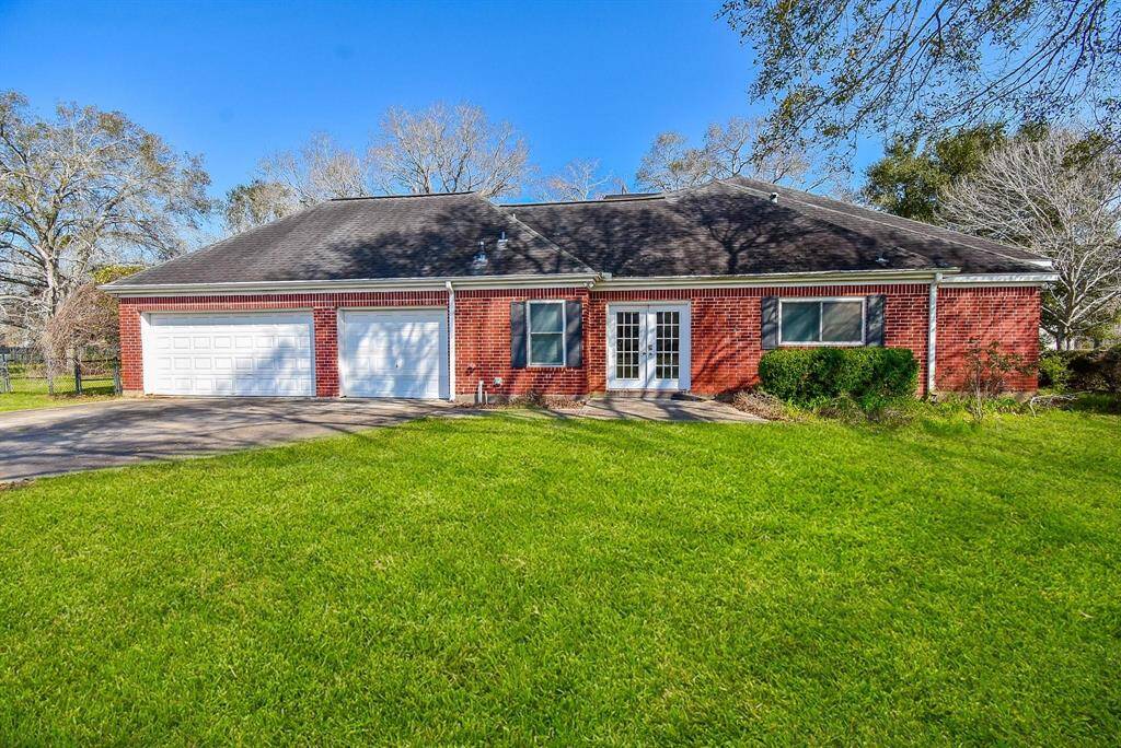 A picturesque side view of the home, showcasing its well-maintained lawn, large windows, and inviting curb appeal.