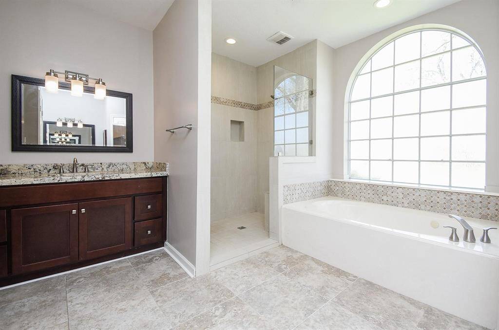 A luxurious primary bathroom retreat with a soaking tub, elegant vanity, and abundant natural light, offering the perfect spa-like escape